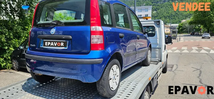 Fiat Panda aux portières latérales enfoncées sur le plateau d’un camion.