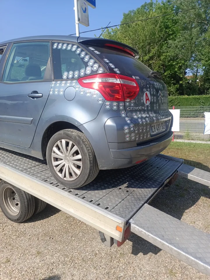 Voiture grise photographiée de l’arrière sur un plateau métallique.