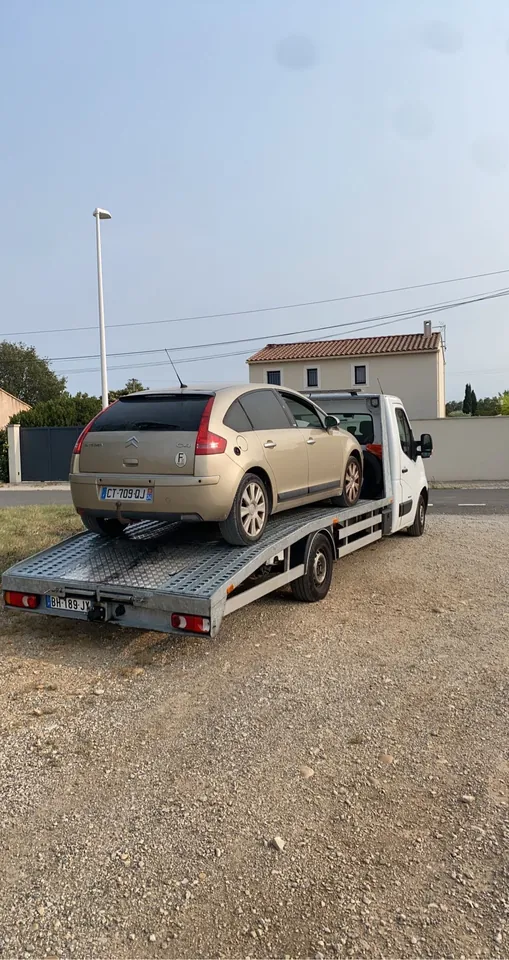 Voiture claire vue de l’arrière sur un plateau dans un espace extérieur.