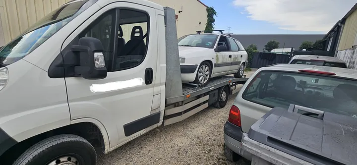 Break chargé sur une dépanneuse à côté d’autres voitures stationnées.