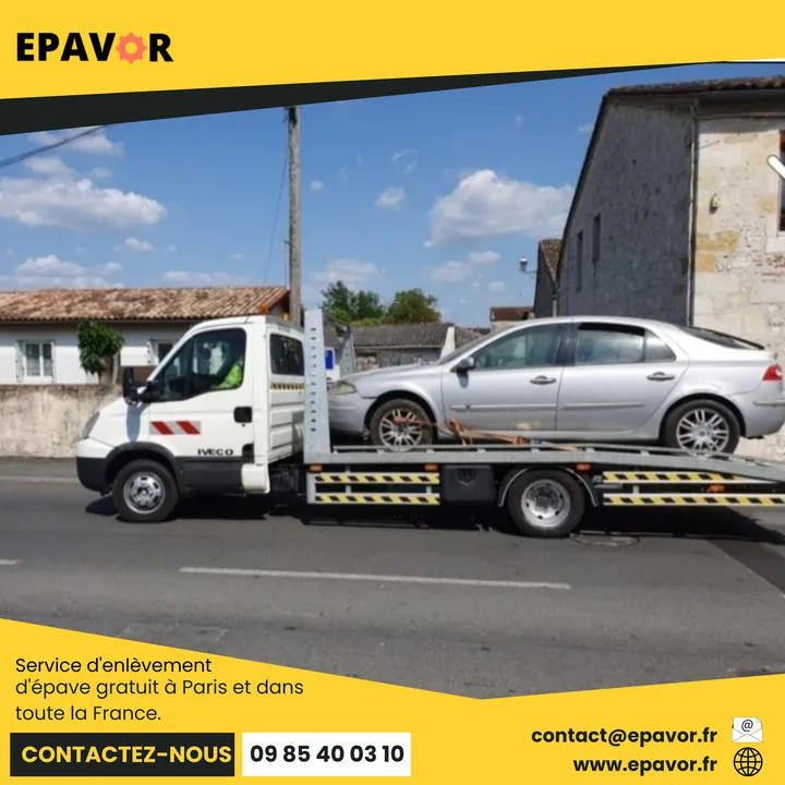 Berline chargée sur un camion blanc avec une sangle près de la roue avant.