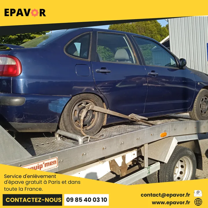 Berline rayée sur une dépanneuse avec une sangle fixée près de la roue arrière.