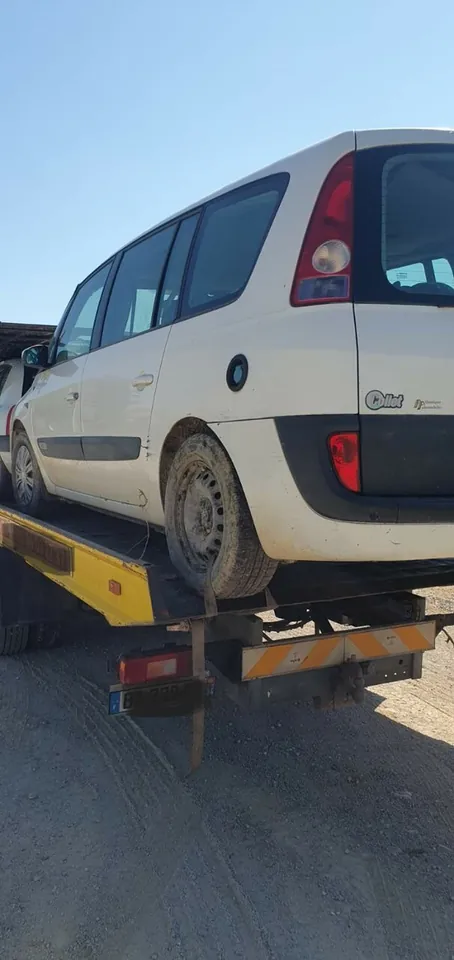 Grand monospace Renault sur la plateforme d’un camion porte-voitures.