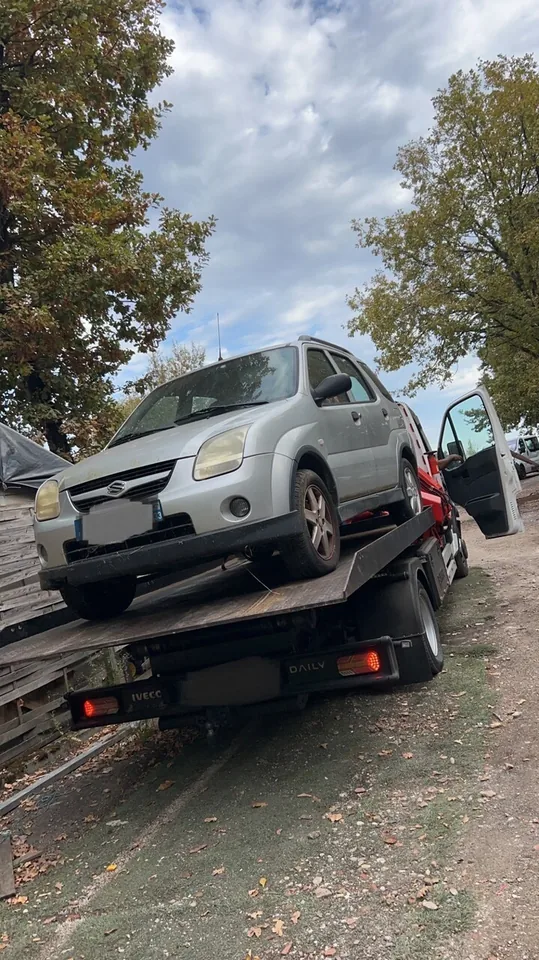 Véhicule Suzuki à carrosserie compacte sur le plateau d’une dépanneuse.