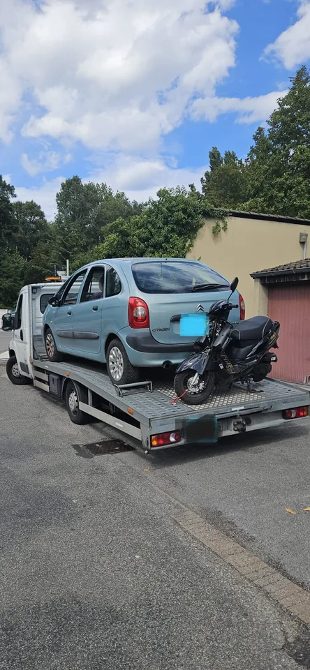 Voiture bleue à l’arrière endommagé installée sur un plateau.