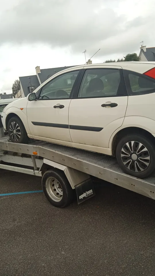 Voiture claire installée sur un plateau, vue depuis son angle arrière.