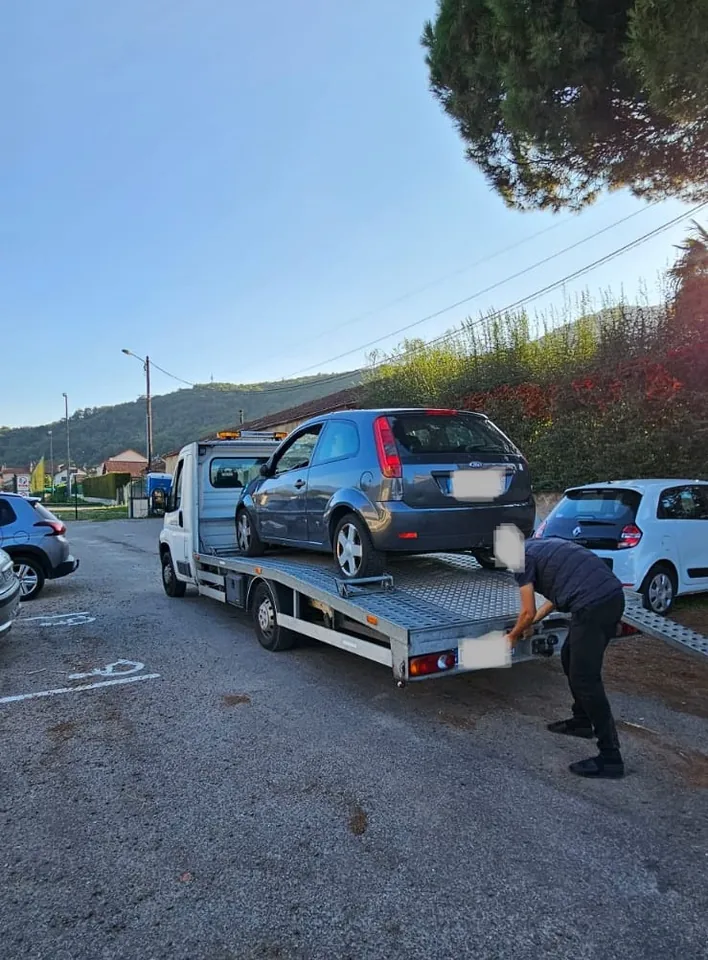 Ford Fiesta sur une dépanneuse avec une personne près de l’arrière du plateau.