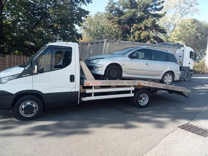 Peugeot 206 SW chargée de profil sur une dépanneuse blanche.