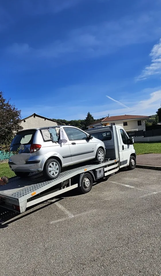 Citadine à trois portes sur un plateau avec une protection sur une vitre latérale arrière.
