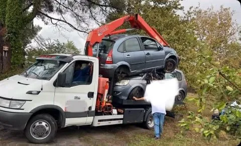 Camion blanc avec grue rouge et plusieurs carrosseries, avec une personne près du plateau.