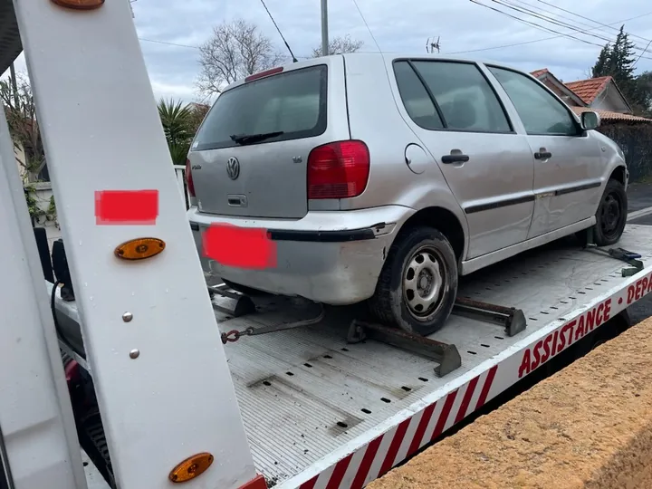 Voiture claire vue de trois quarts arrière sur un plateau, avec des zones déjà masquées sur l’image.