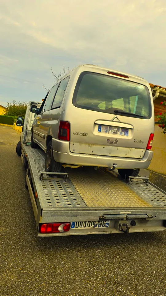 Voiture claire sur un plateau, photographiée depuis l’arrière avec le ciel en fond.