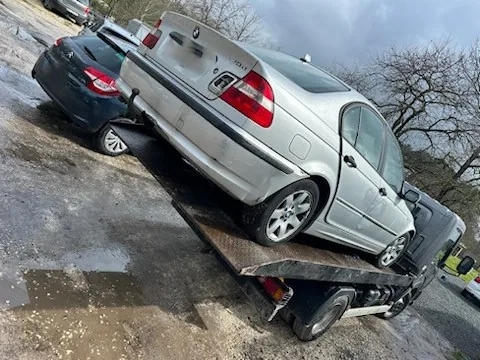 Voiture claire photographiée de trois quarts arrière sur un camion plateau.
