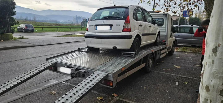 Voiture claire sur un plateau, vue depuis l’arrière du camion.