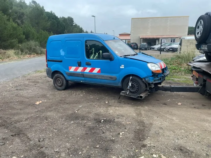 Fourgonnette bleue dont les roues avant reposent sur un berceau de levage et les roues arrière restent au sol.