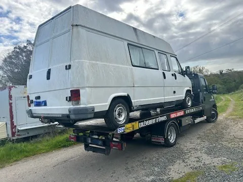 Grand fourgon blanc à toit haut installé sur un camion plateau.