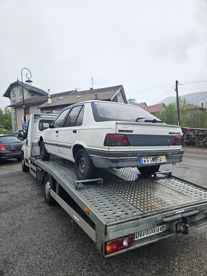 Voiture claire à carrosserie allongée photographiée de l’arrière sur un plateau.