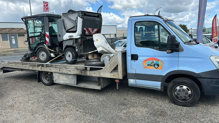 Carrosserie de véhicule avec plusieurs éléments absents installée sur un camion plateau.