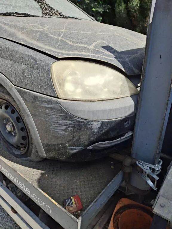 Avant poussiéreux et pare-chocs rayé d’une voiture sur un plateau.