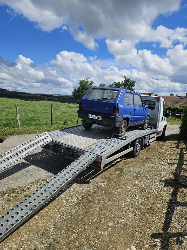 Petite voiture bleue sur un plateau, avec deux rampes dirigées vers le sol.