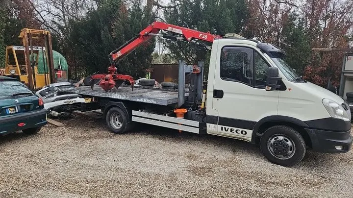 Grue rouge déployée avec une pince ouverte au-dessus d’un plateau.