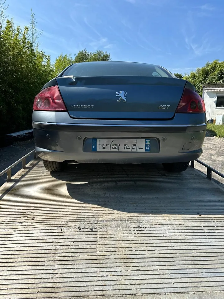 Arrière d’une berline sombre installée sur un plateau métallique.