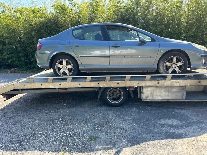 Berline claire à quatre portes entièrement chargée sur une dépanneuse.