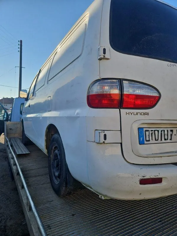 Partie arrière d’un fourgon blanc photographiée sur un plateau de transport.